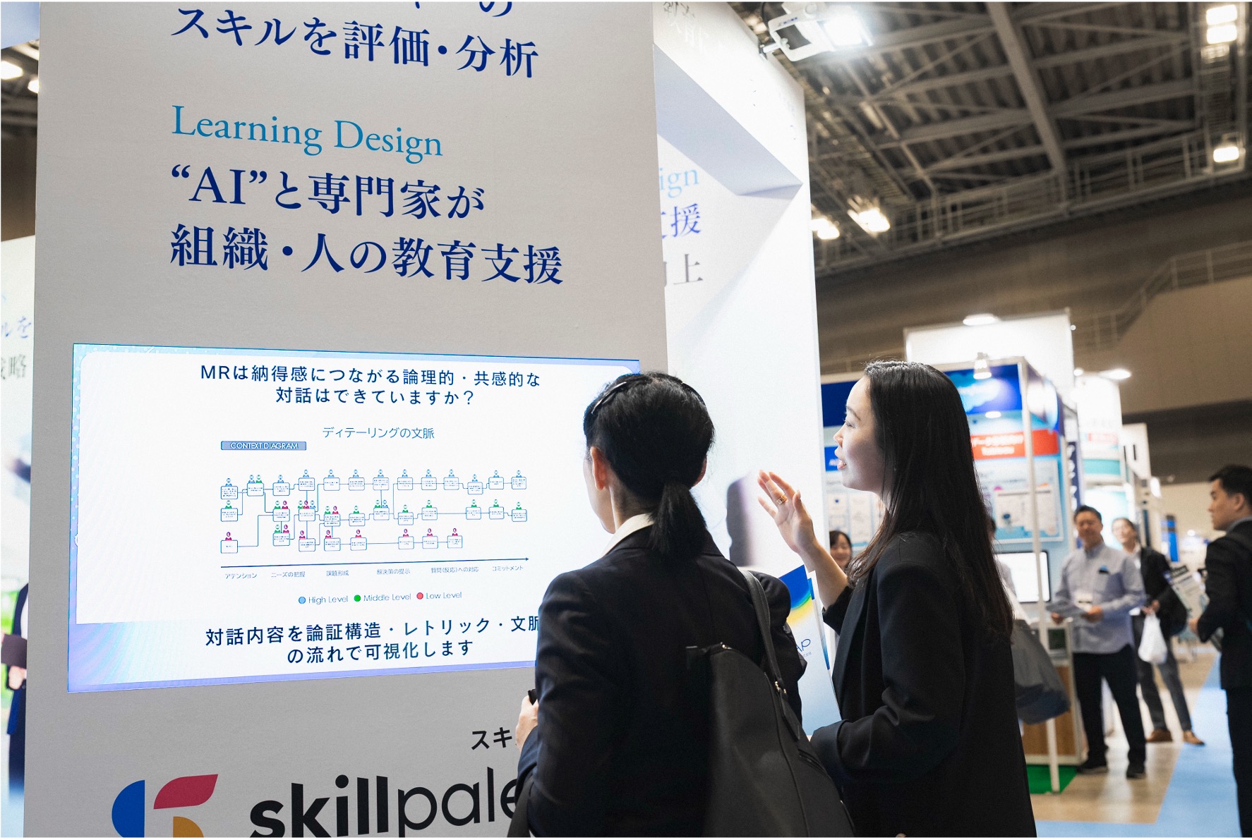 展示会場のブースで説明を受ける来場者